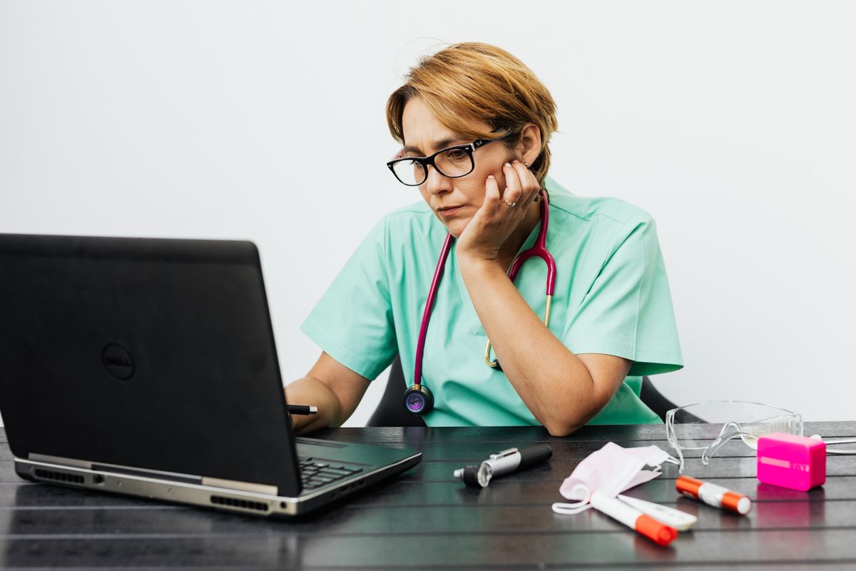 A nurse comparing online RN to BSN programs while studying at a laptop at home